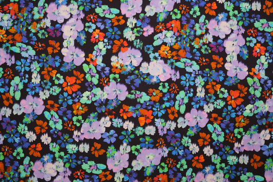 Baumwolljersey mit bunten Aquarell-Blumen auf dunklem Hintergrund – Detailaufnahme der Stoffstruktur