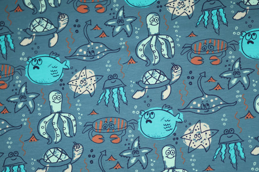 Bunter Ozeanstoff mit Fischen, Schildkröten und Quallen.