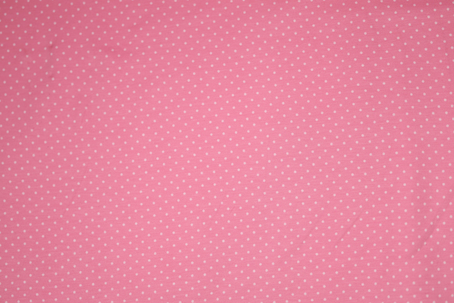 Zartes Punktmuster auf rosa Baumwollstoff – ideal für Baby- und Kinderkleidung.