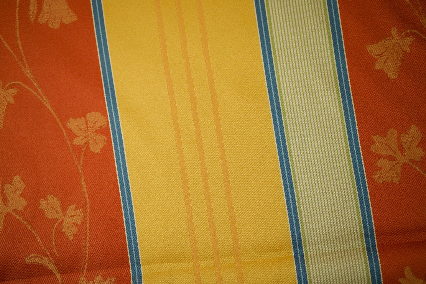Vorhangstoff mit floralen Details in warmen Terrakotta- und Gelbtönen
