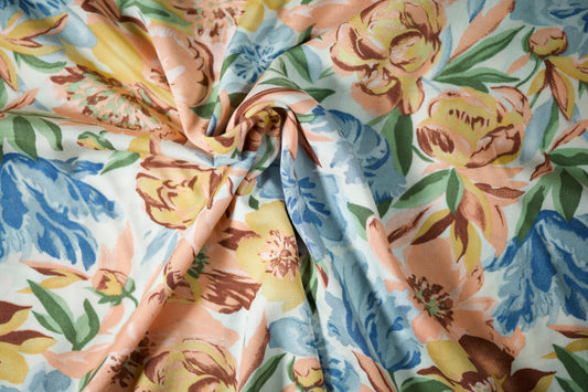 Viskosestoff – Blumenwiese in Pastellgelb & Himmelblau – Viskosestoff mit Blumenmuster – weich und ideal für sommerliche Kleidung – Stoffstruktur im Nahaufnahme