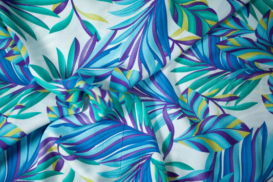 Viskosestoff – Tropenblätter in Türkis & Violett – Viskosestoff mit Blumenmuster – weich und ideal für sommerliche Kleidung – Stoffstruktur im Nahaufnahme