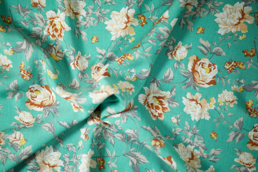 Sommerlicher Stoff mit floralen Elementen auf Türkis