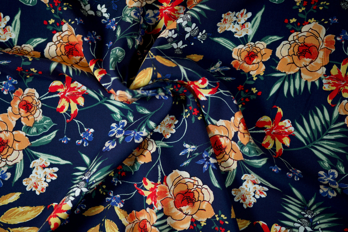 Viskosestoff mit bunten Blumen auf marineblauem Hintergrund