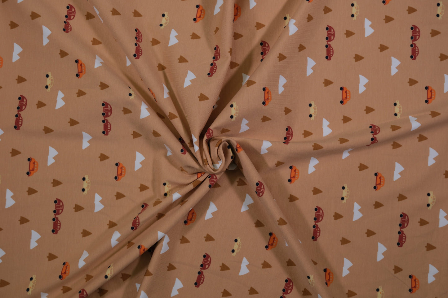 Beiger Baumwolljersey mit Autos, Bäumen und Bergen – Detailaufnahme der Stoffstruktur