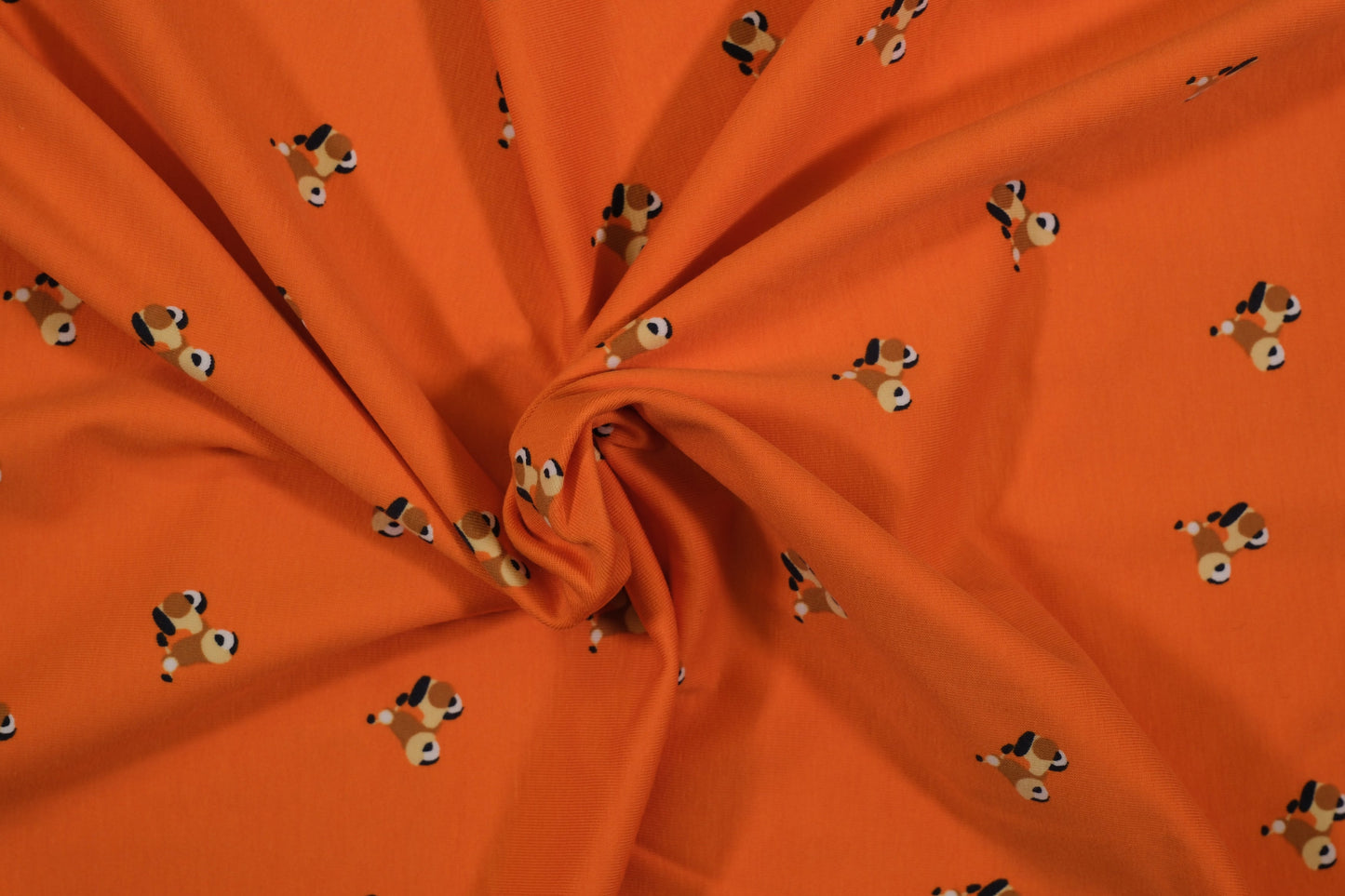 Oranger Baumwolljersey mit kleinen Hundemotiven – Detailaufnahme der Stoffstruktur