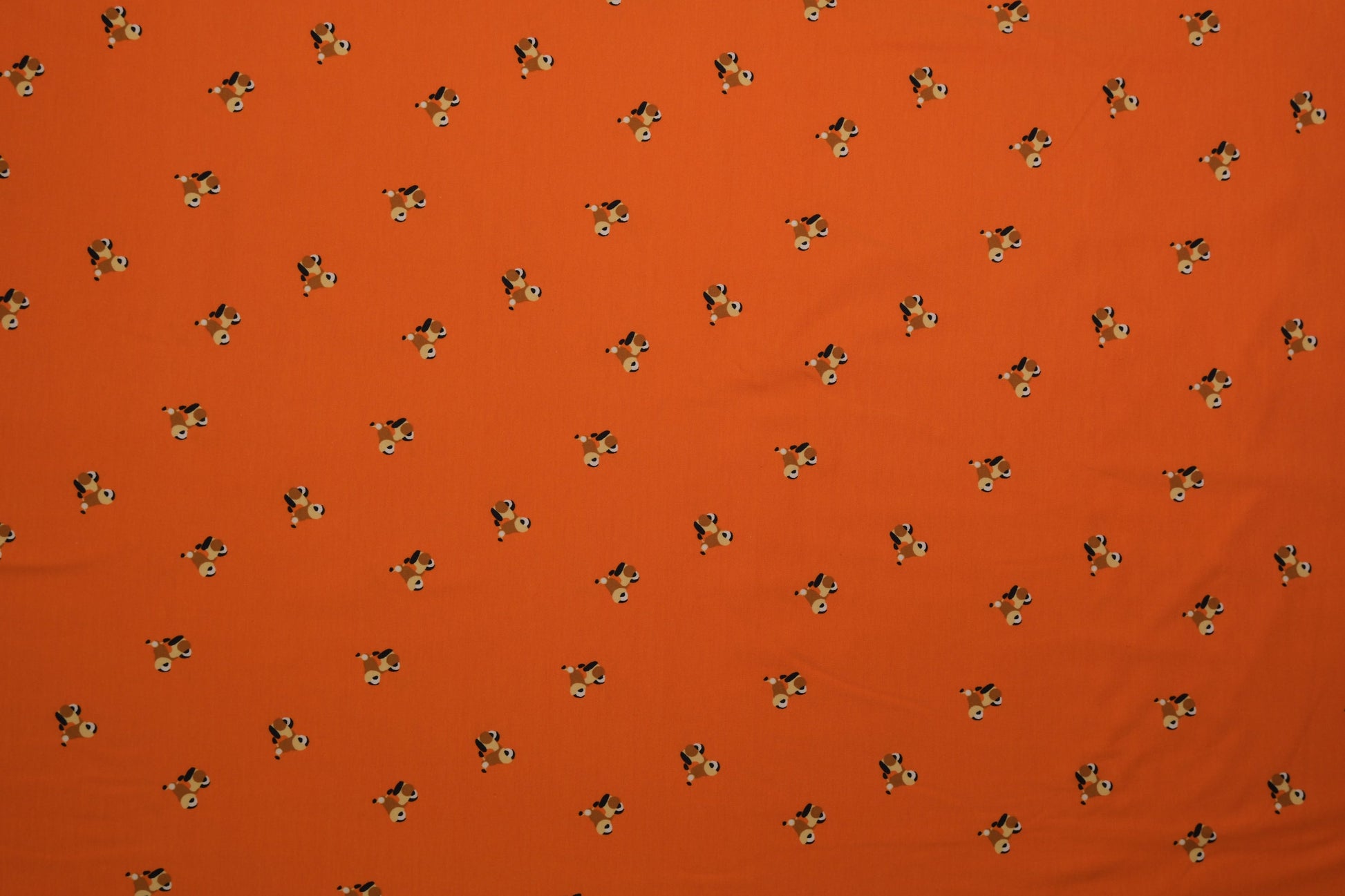Oranger Baumwolljersey mit kleinen Hundemotiven – 140 cm breit