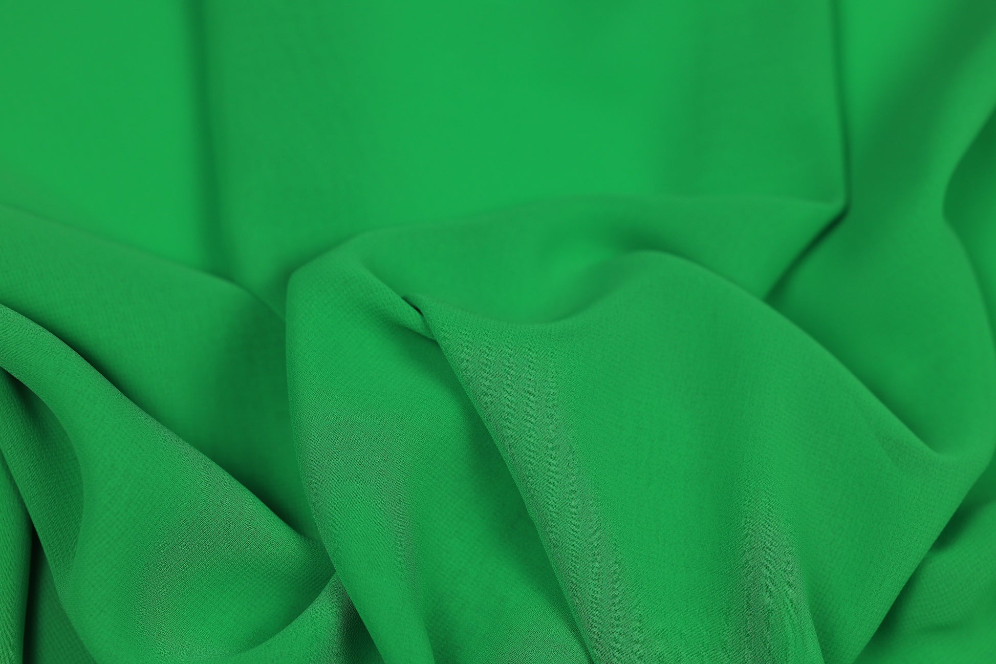 Grüner fließender Chiffonstoff mit elegantem Faltenwurf – ideal für Kleider und Blusen