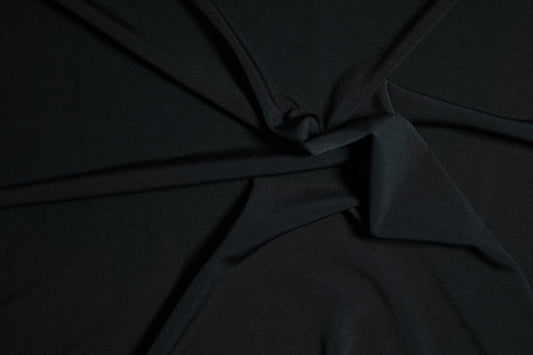 Klassischer Jerseystoff in tiefem Schwarz, spiralförmig drapiert