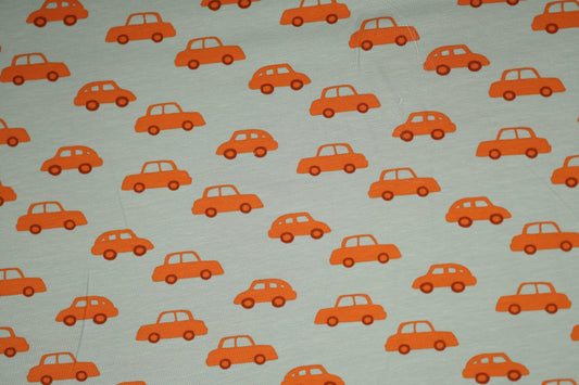 Kinderstoff aus Baumwolle mit orangen Autos auf hellgrauem Hintergrund.