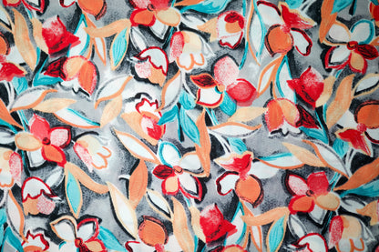 Viskosestoff mit Blumen in Rot und Orange auf dunklem Grund
