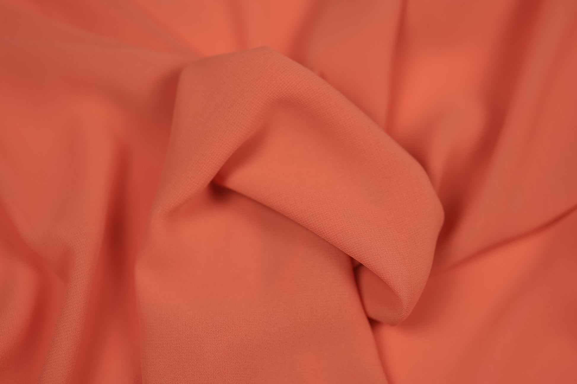 Detailaufnahme von Chiffonstoff in Koralle – halbtransparent und edel fallend