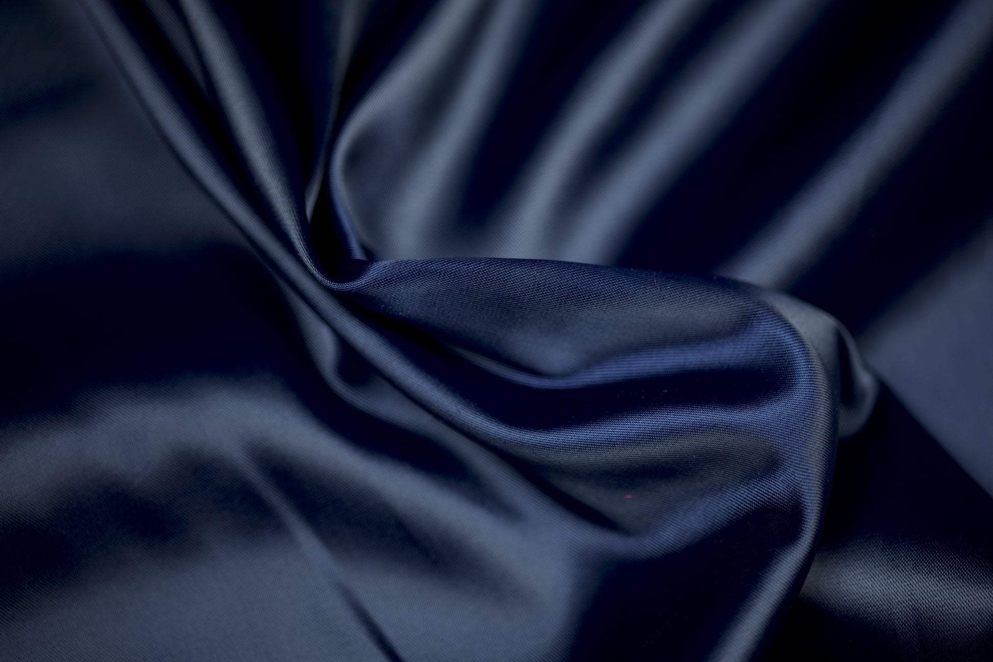 Satinstoff in edlem Nachtblau mit weichem Glanz und eleganter Faltenstruktur – ideal für Abendmode und klassische Dekorationen